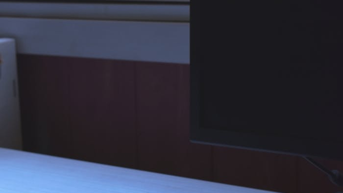 Minimalist workspace featuring a sleek keyboard and monitor by a window.