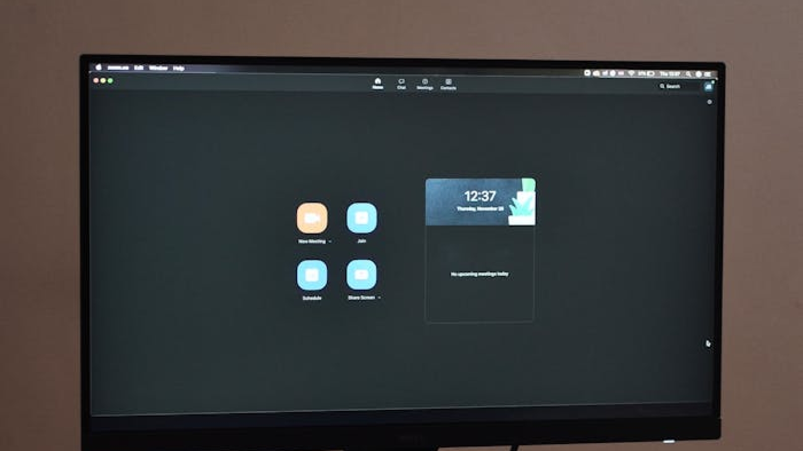 A sleek desktop setup featuring a monitor, keyboard, and mouse on a patterned tablecloth.