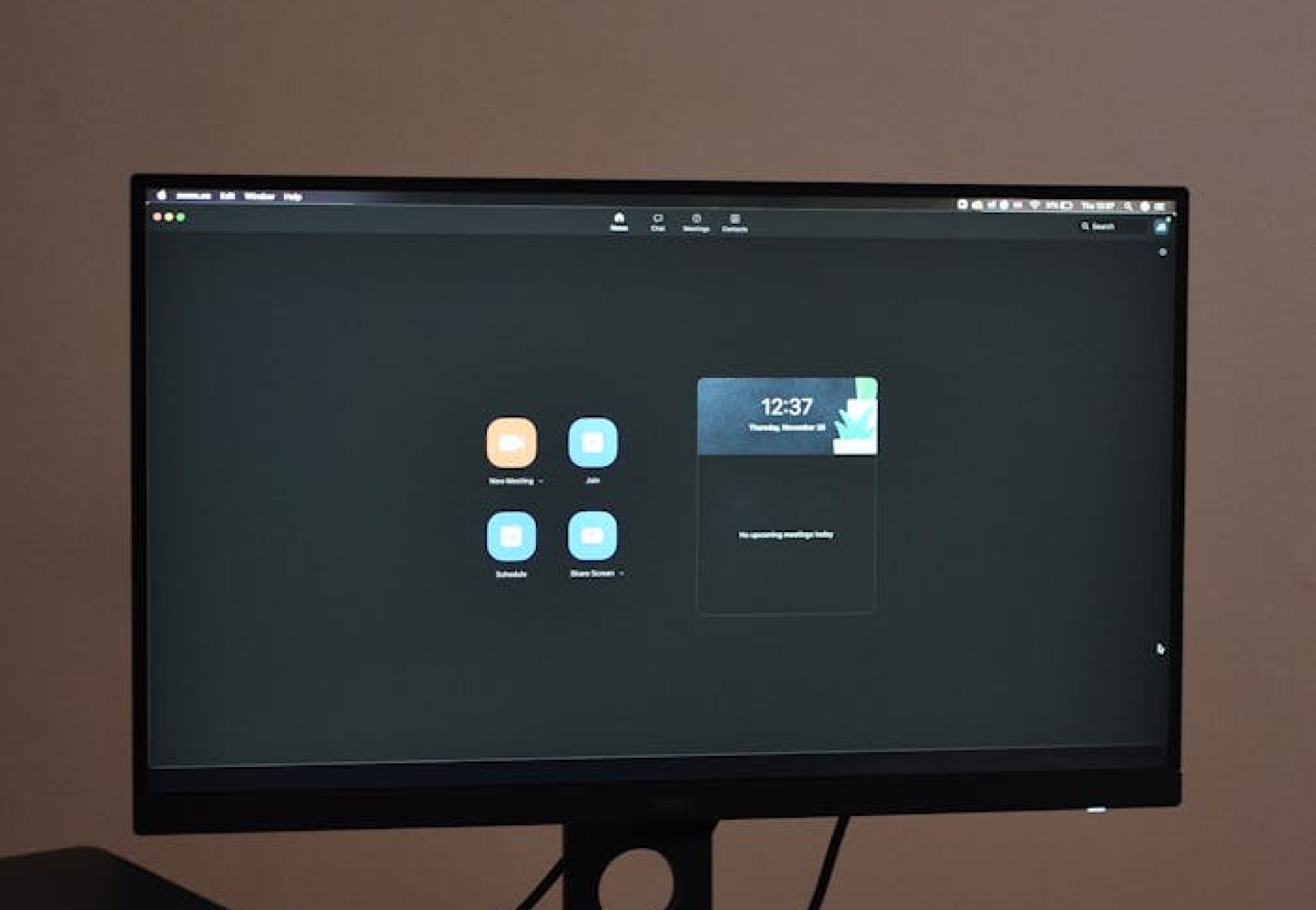 A sleek desktop setup featuring a monitor, keyboard, and mouse on a patterned tablecloth.