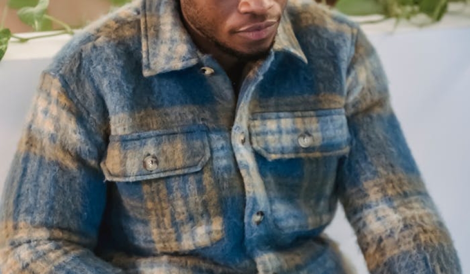Young man in a casual setting intensely focused on his laptop, indoors.